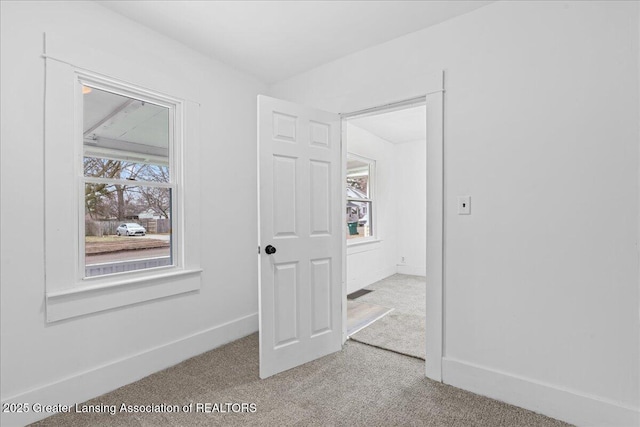 interior space featuring a healthy amount of sunlight, baseboards, and carpet flooring