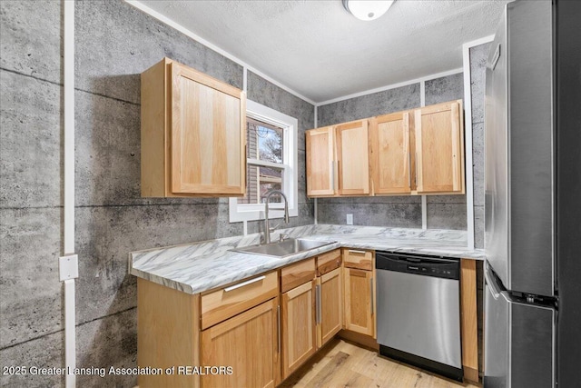 kitchen with light brown cabinetry, appliances with stainless steel finishes, light wood-style floors, ornamental molding, and a sink