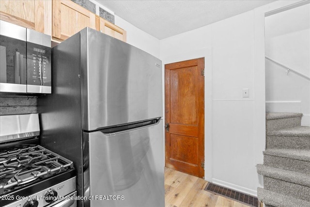 kitchen with visible vents, appliances with stainless steel finishes, and wood finished floors