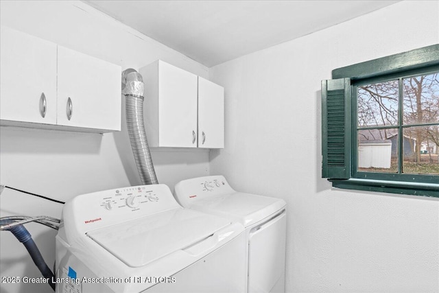 clothes washing area with washer and dryer and cabinet space