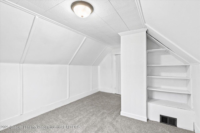 bonus room with vaulted ceiling, carpet, and visible vents