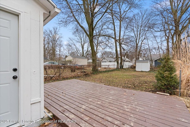 wooden deck featuring an outdoor structure and fence