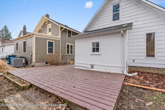 back of property with a deck, central AC unit, and a chimney