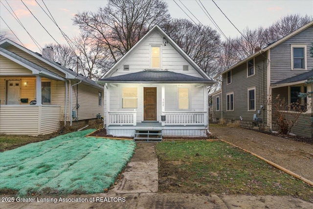 view of front of house with covered porch and a front lawn