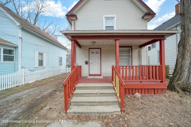 view of front of home featuring a porch and fence