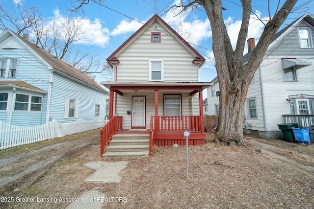 view of front of home featuring covered porch and fence