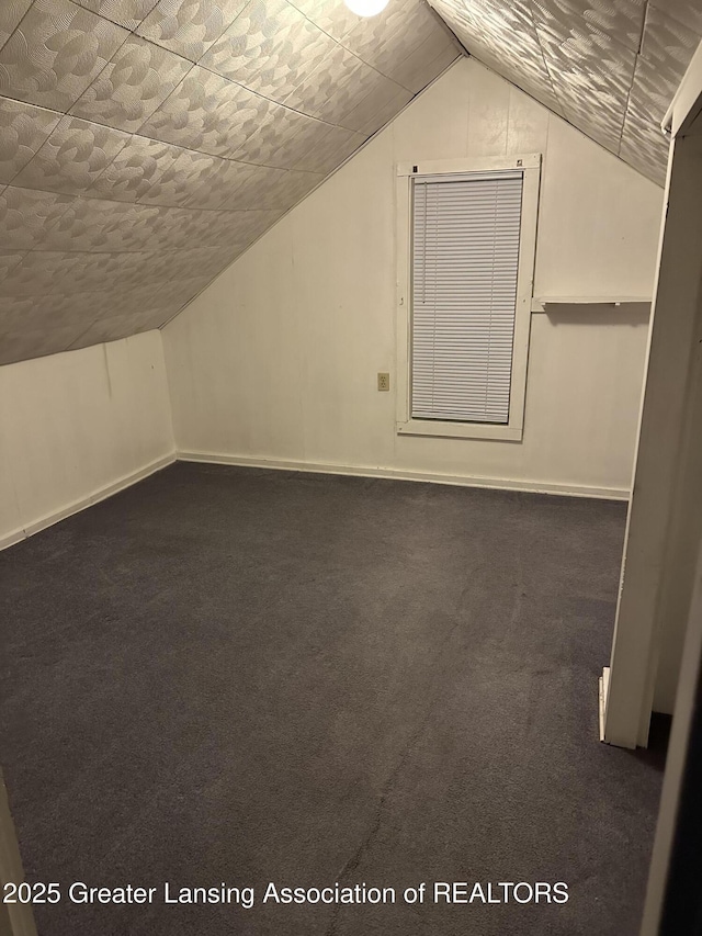 bonus room featuring carpet floors, baseboards, and lofted ceiling