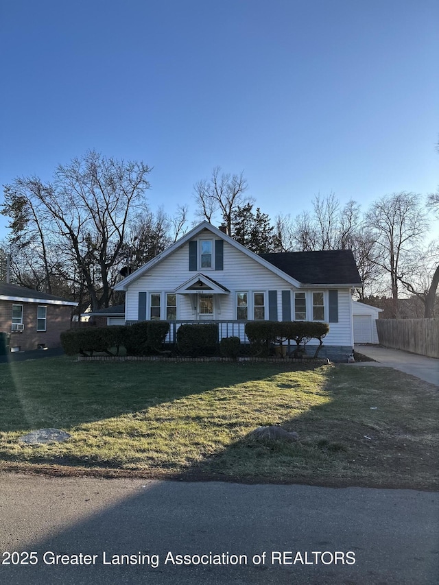 bungalow-style house with fence and a front lawn