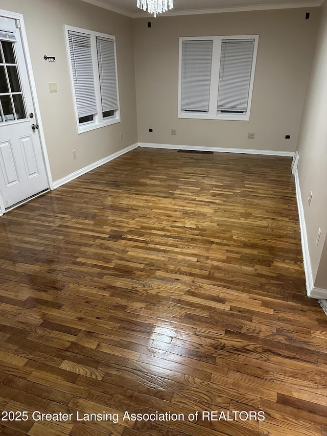 spare room featuring dark wood-style floors and baseboards