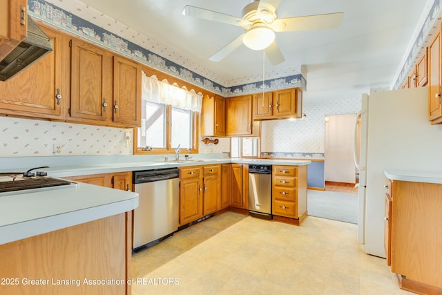 kitchen with wallpapered walls, stainless steel dishwasher, light countertops, light floors, and a sink