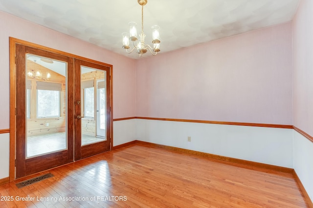 unfurnished room with french doors, light wood-style flooring, visible vents, and baseboards