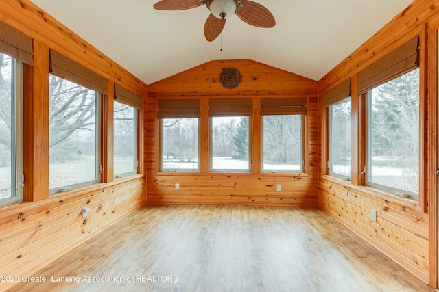 unfurnished sunroom with a ceiling fan, lofted ceiling, and plenty of natural light