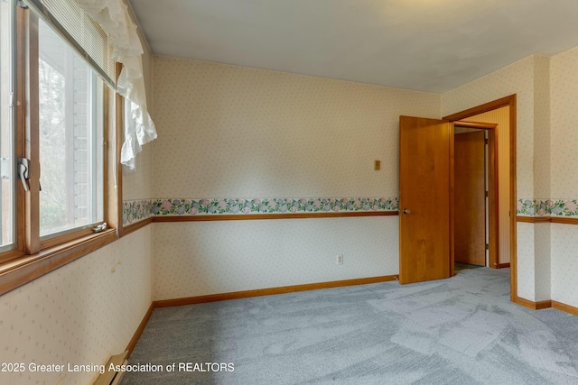 carpeted spare room with baseboards and wallpapered walls