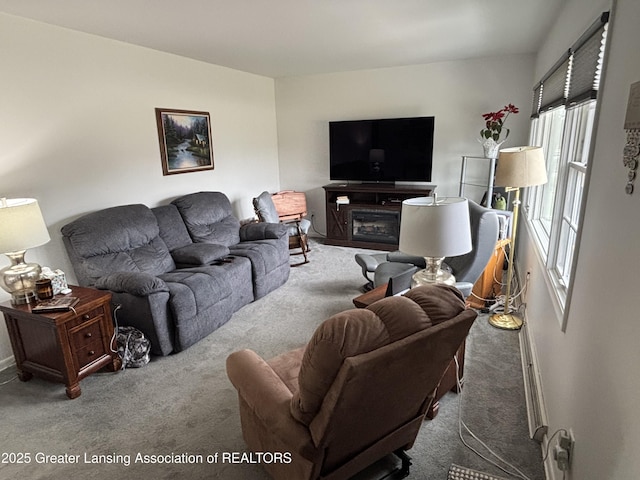 carpeted living area with a glass covered fireplace