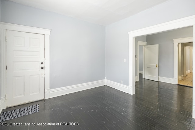 unfurnished room with wood finished floors and baseboards