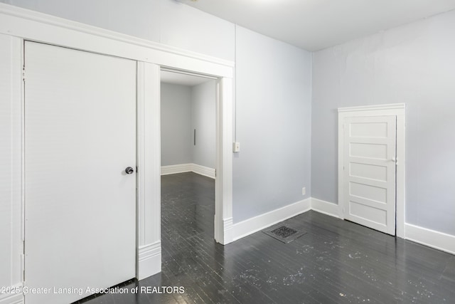 spare room featuring visible vents, wood finished floors, and baseboards