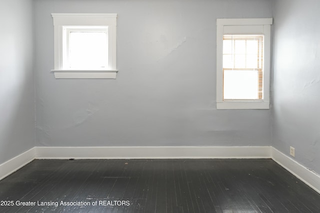 empty room featuring baseboards and dark wood-style flooring