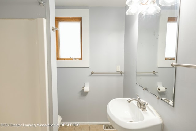 bathroom with visible vents, baseboards, toilet, tile patterned floors, and a sink