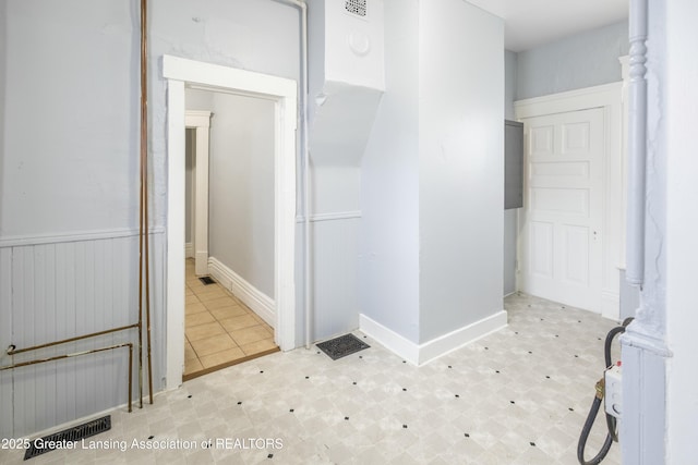 bathroom with tile patterned floors and wainscoting