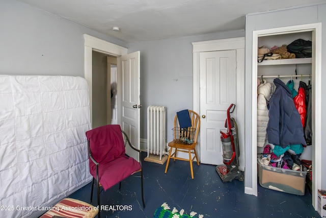 interior space featuring a closet, radiator, and finished concrete floors