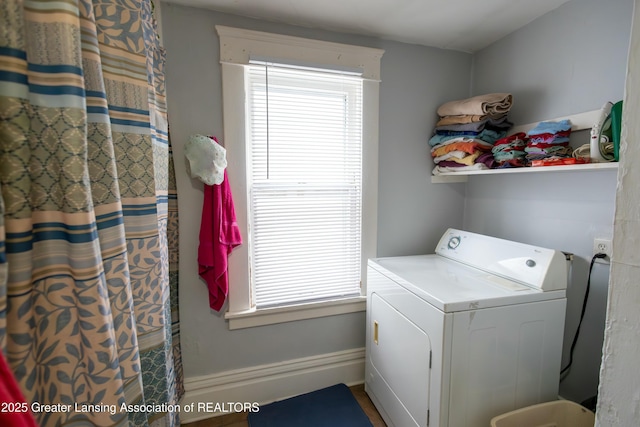 clothes washing area featuring laundry area, washer / dryer, and baseboards