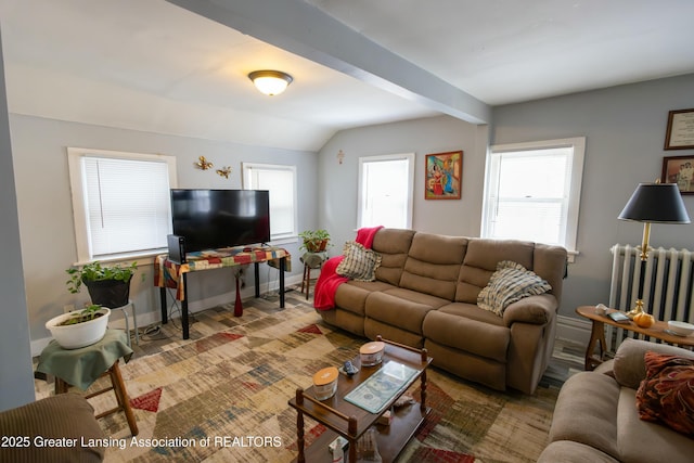 living area featuring lofted ceiling with beams, baseboards, and radiator heating unit