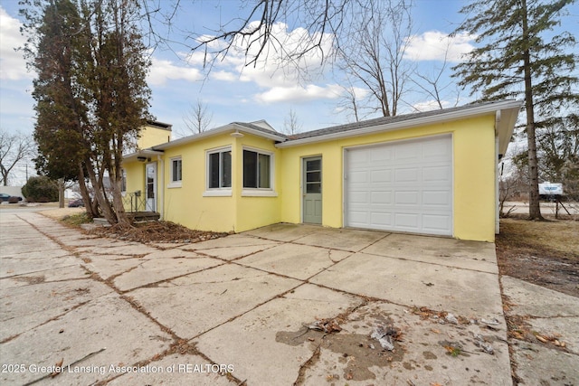 view of side of property with a garage, concrete driveway, and stucco siding