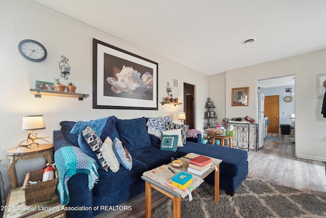 living area with wood finished floors and visible vents