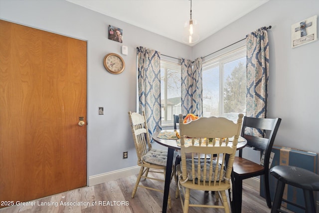 dining area with baseboards and wood finished floors