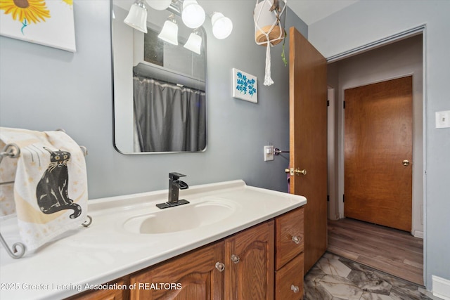 full bathroom featuring marble finish floor and vanity