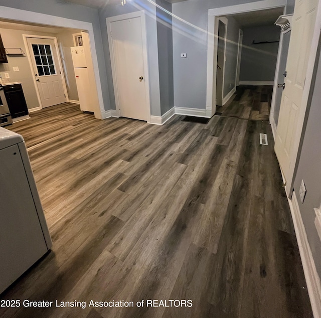 interior space with dark wood-type flooring, baseboards, and visible vents