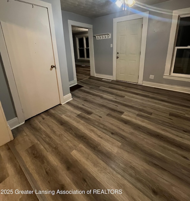 entryway with dark wood finished floors and baseboards