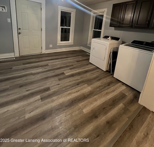 washroom featuring washer and dryer, cabinet space, dark wood-style floors, and baseboards