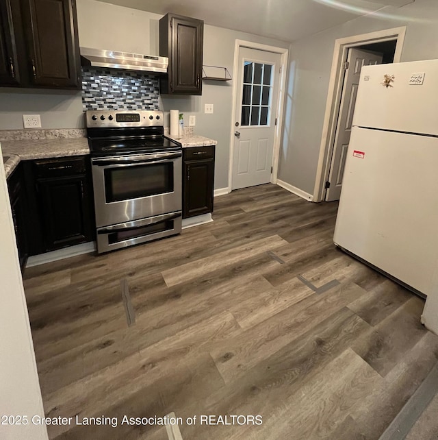 kitchen with electric range, under cabinet range hood, freestanding refrigerator, light countertops, and dark wood-style flooring