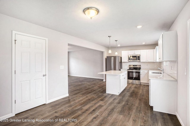 kitchen with tasteful backsplash, appliances with stainless steel finishes, dark wood finished floors, and a sink