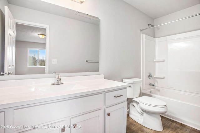 full bathroom with wood finished floors, shower / washtub combination, vanity, and toilet