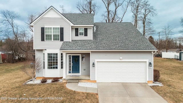 traditional-style home featuring a shingled roof, concrete driveway, a front lawn, and a garage