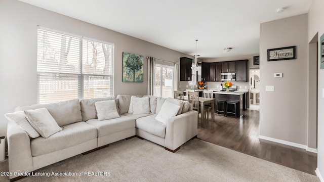 living area with baseboards and dark wood finished floors