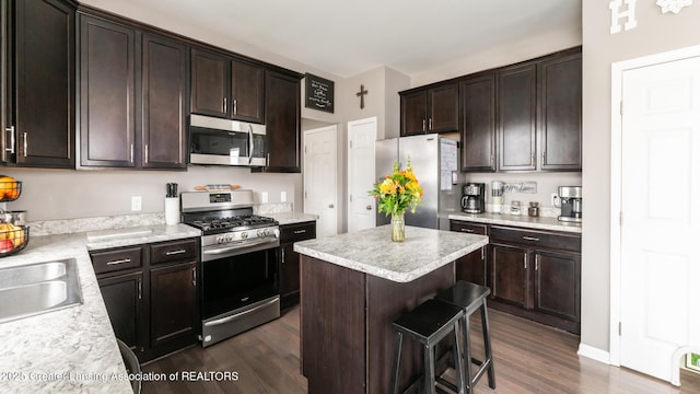 kitchen with stainless steel appliances, light countertops, dark brown cabinetry, and dark wood-type flooring