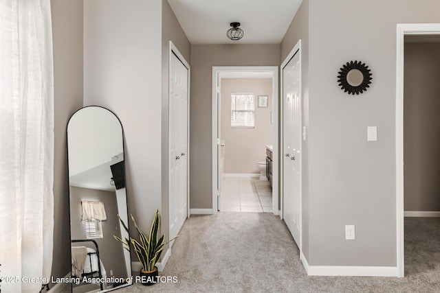 hallway with a wealth of natural light, carpet, and baseboards