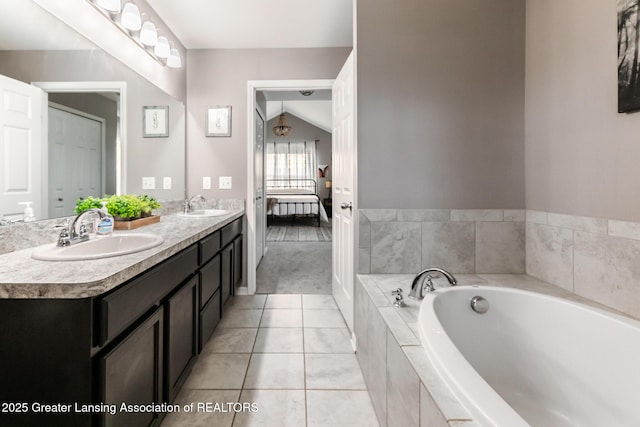 ensuite bathroom with a garden tub, double vanity, ensuite bath, and a sink