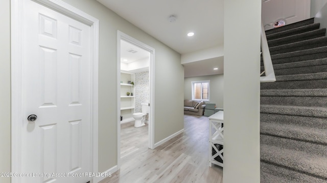 interior space with built in features, recessed lighting, visible vents, wood finished floors, and baseboards