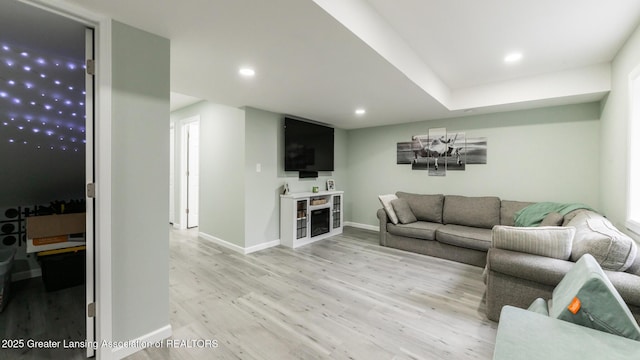 living room with light wood finished floors, baseboards, and recessed lighting