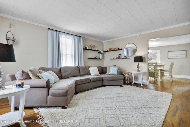 living room featuring ornamental molding, wood finished floors, and baseboards