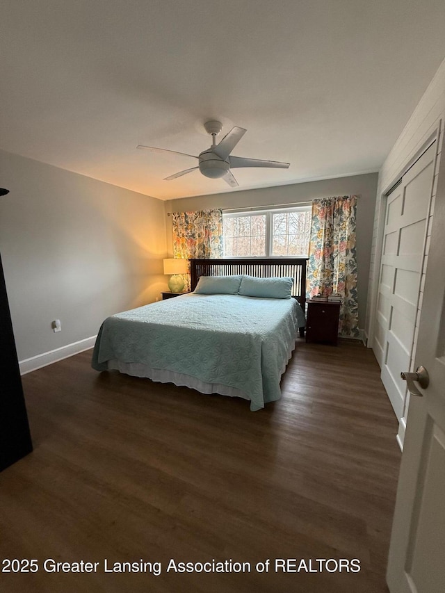 unfurnished bedroom featuring dark wood-type flooring, a closet, ceiling fan, and baseboards