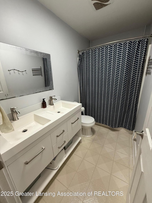 full bathroom with toilet, a shower with curtain, visible vents, and a sink