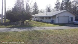 ranch-style home featuring a garage, driveway, and a front lawn