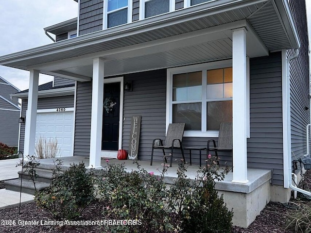 entrance to property featuring a garage and covered porch