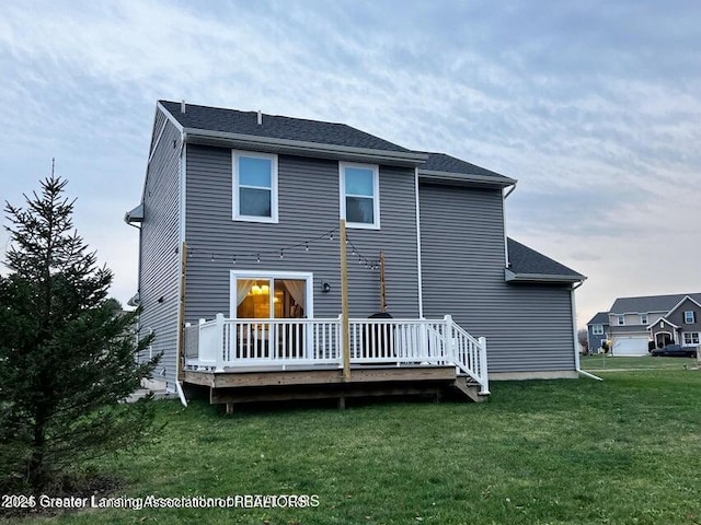 back of house with a deck and a yard