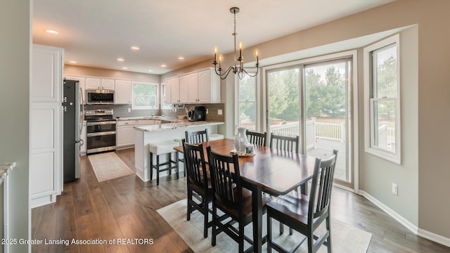 dining room featuring dark wood-type flooring, recessed lighting, a chandelier, and baseboards